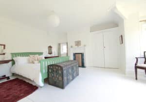 Big green bed in large bedroom in holiday house