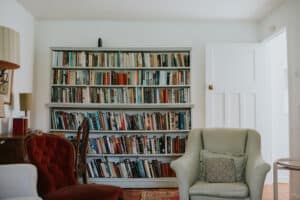 Bookshelf in a Dorset seaside accommodation with comfortable armchairs, perfect for reading.
