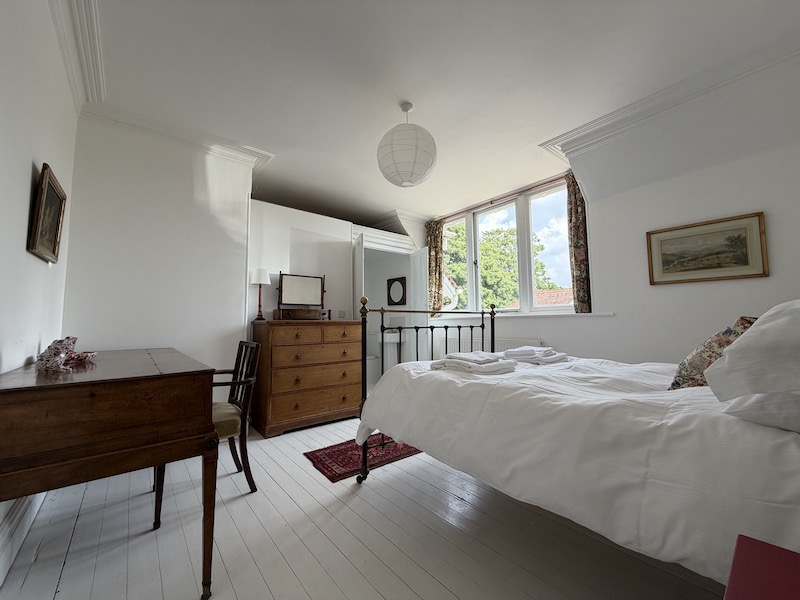Bedroom view, with bedstead and shower room just visible beyond the bed